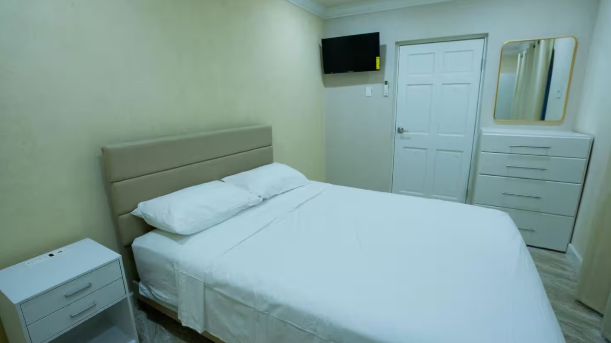 Bedroom with queen bed, TV and white dresser